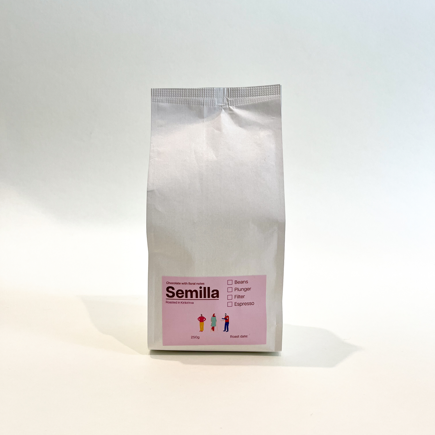 A white bag of TLF Semilla coffee with a pink label.